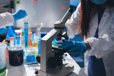 Bilimadamı laboratuarda tıbbi örnekleri mikro plakaya yerleştiriyor.