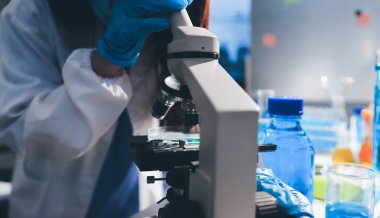 Bilimadamı laboratuarda tıbbi örnekleri mikro plakaya yerleştiriyor.