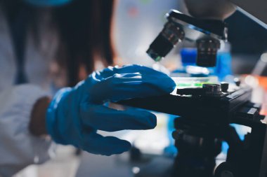 Bilimadamı laboratuarda tıbbi örnekleri mikro plakaya yerleştiriyor.