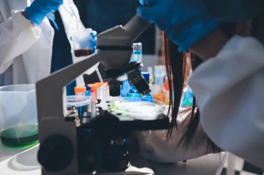 Bilimadamı laboratuarda tıbbi örnekleri mikro plakaya yerleştiriyor.