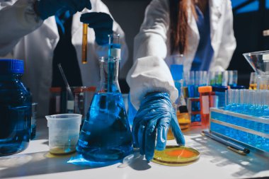 Bilimadamı laboratuarda tıbbi örnekleri mikro plakaya yerleştiriyor.