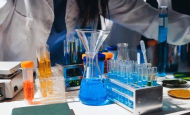 Bilimadamı laboratuarda tıbbi örnekleri mikro plakaya yerleştiriyor.