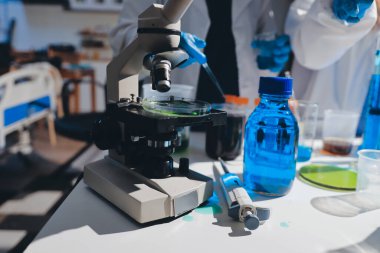 Bilimadamı laboratuarda tıbbi örnekleri mikro plakaya yerleştiriyor.