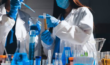 Bilimadamı laboratuarda tıbbi örnekleri mikro plakaya yerleştiriyor.