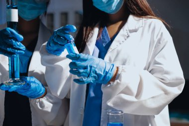 Bilimadamı laboratuarda tıbbi örnekleri mikro plakaya yerleştiriyor.