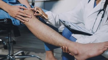 Yakın plan - erkek doktorun steteskopla bacağı muayene edişi