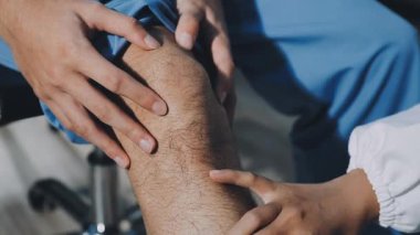 Hastanede hastanın bacağını muayene eden doktor.