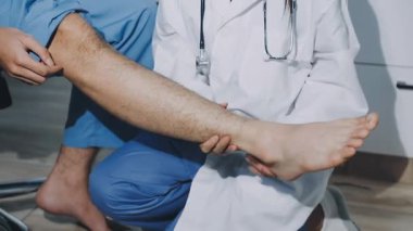 Hastanede bacağı olan erkek hastayı muayene eden fizyoterapist. Sağlık ve Tıp Konsepti.