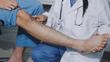 Doktor hastanede bacağını muayene ediyor.