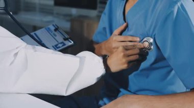 Klinikte çalışan üniformalı genç erkek doktor..