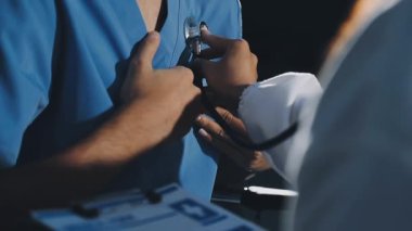 Steteskoplu genç erkek doktor klinikte çalışıyor.