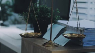 Adalet terazisi ve yasal belgeler büro masasında.