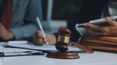 Avukat ya da avukat ya da avukat ya da avukat bürodaki bir masada yasal belgeler ve belgeler üzerinde çalışıyor.