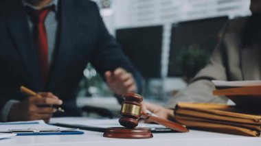 İş yerinde tokmak ve belgelerle çalışan takım elbiseli bir işadamı.