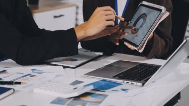 Modern ofiste grafiği olan bilgisayar ve dijital tablet kullanan işadamlarının görünümünü kapat.