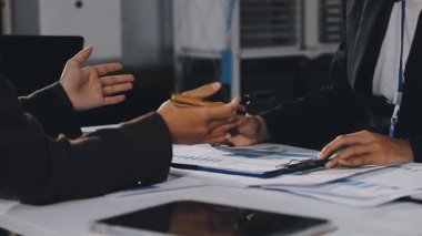 İş ekibi masaüstünde finansal grafikleri ve grafikleri tartışıyor