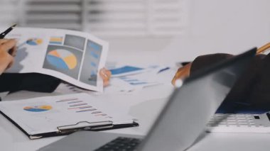 İş adamları ofiste finansal çizelge ve çizelgeleri tartışıyor.