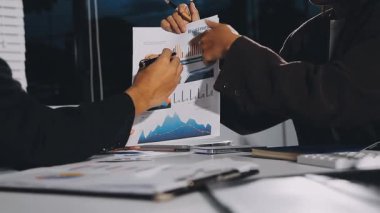 Genç iş adamları ofis masasında projeyi tartışıyor.