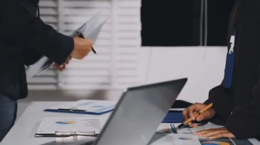 Ofiste dizüstü bilgisayarı olan genç bir iş adamı..