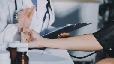 Kadın doktor elinde haplar ve steteskop tutuyor..