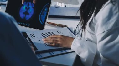 Genç Asyalı kadın doktor hastanede tablet bilgisayar kullanıyor.