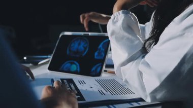 MRI 'ı inceleyen üniformalı kadın doktor klinikte sonuç veriyor..