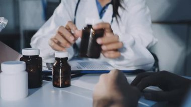 Hastane ofisinde elinde tablet ve haplar tutan bir doktor.