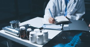 Erkek ve kadın doktorlar bir hastane odasında toplantı yapıyorlar..