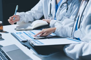 Erkek ve kadın doktorlar bir hastane odasında toplantı yapıyorlar..