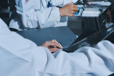 Erkek ve kadın doktorlar bir hastane odasında toplantı yapıyorlar..