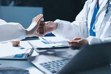 Erkek ve kadın doktorlar bir hastane odasında toplantı yapıyorlar..