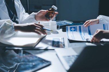 Erkek ve kadın doktorlar bir hastane odasında toplantı yapıyorlar..