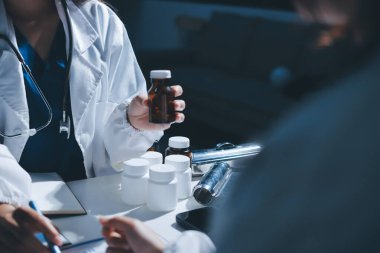 Erkek ve kadın doktorlar bir hastane odasında toplantı yapıyorlar..