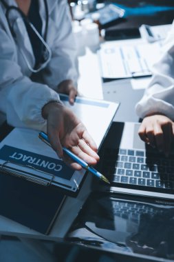 Erkek ve kadın doktorlar bir hastane odasında toplantı yapıyorlar..