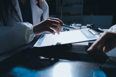 Erkek ve kadın doktorlar bir hastane odasında toplantı yapıyorlar..