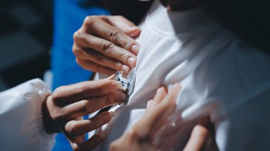 Konuşurken kalp atışı ve semptomlarını incelemek için steteskop kullanan erkek doktorun el görüntüsü.