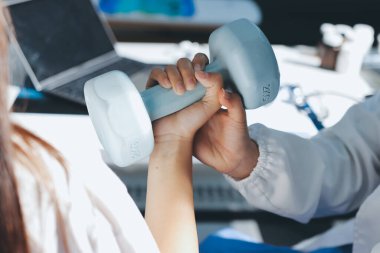 Tanımlanamayan fiziksel terapi sırasında mavi el ağırlığı kullanır