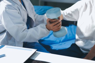 Tanımlanamayan fiziksel terapi sırasında mavi el ağırlığı kullanır