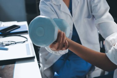 Tanımlanamayan fiziksel terapi sırasında mavi el ağırlığı kullanır