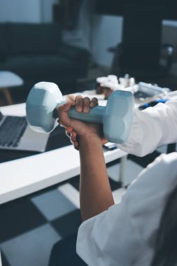 Tanımlanamayan fiziksel terapi sırasında mavi el ağırlığı kullanır