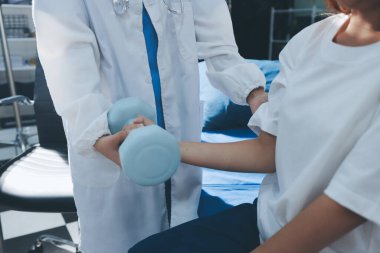 Tanımlanamayan fiziksel terapi sırasında mavi el ağırlığı kullanır