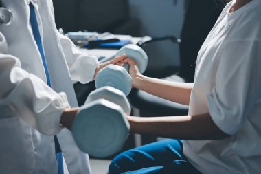 Tanımlanamayan fiziksel terapi sırasında mavi el ağırlığı kullanır