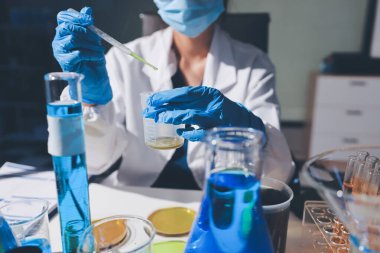 Bilimadamı laboratuarda tıbbi örnekleri mikro plakaya yerleştiriyor.