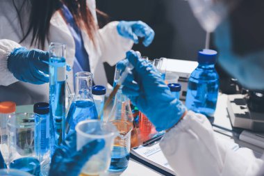 Bilimadamı laboratuarda tıbbi örnekleri mikro plakaya yerleştiriyor.