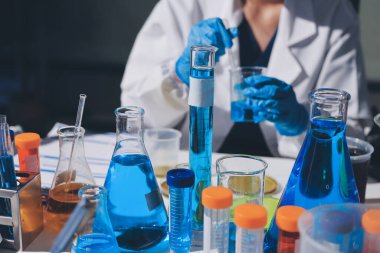 Bilimadamı laboratuarda tıbbi örnekleri mikro plakaya yerleştiriyor.