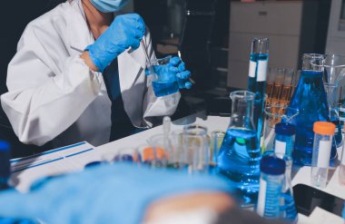 Bilimadamı laboratuarda tıbbi örnekleri mikro plakaya yerleştiriyor.