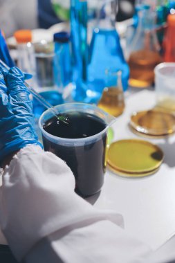 Bilimadamı laboratuarda tıbbi örnekleri mikro plakaya yerleştiriyor.