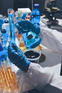 Bilimadamı laboratuarda tıbbi örnekleri mikro plakaya yerleştiriyor.