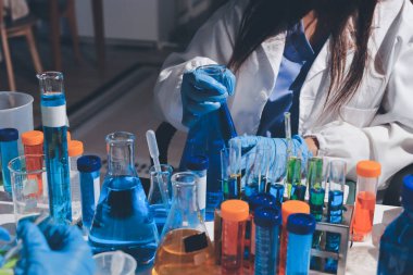 Bilimadamı laboratuarda tıbbi örnekleri mikro plakaya yerleştiriyor.