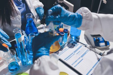 Bilimadamı laboratuarda tıbbi örnekleri mikro plakaya yerleştiriyor.